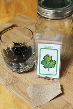 a jar filled with lots of blackberries next to a cut up piece of paper