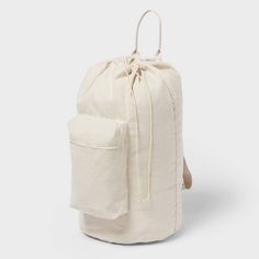 a white canvas backpack with a drawstring on the front and back pocket,