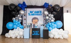 an image of a birthday party setup with balloons and presents on the stage in front of it