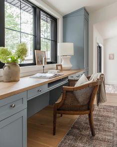 a chair sitting in front of a window on top of a wooden desk next to a lamp