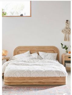 a bed sitting in the middle of a bedroom next to a table and lamp on top of a rug