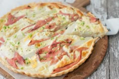 a pizza sitting on top of a wooden cutting board covered in cheese and toppings