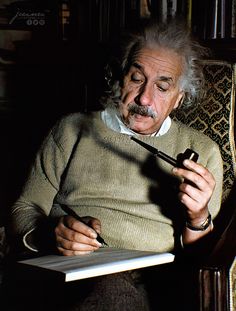 an old man sitting in a chair holding a pipe and writing on a book with a pen