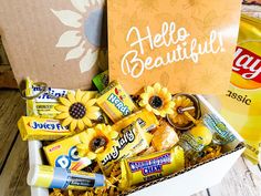 an open box filled with candy and sunflowers