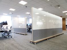 an office cubicle with two desks and chairs