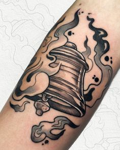 a black and white photo of a tattoo with a large bell on it's arm