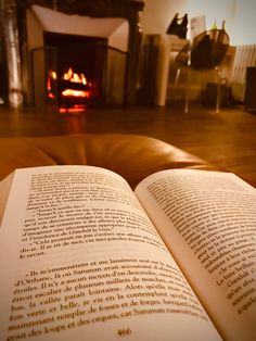 an open book sitting in front of a fire place