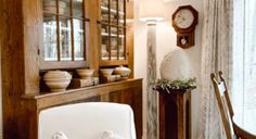 a dining room table and chairs in front of a clock