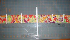 the ruler is next to an orange and green paisley pattern on a gray background with yellow lines