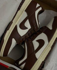 a pair of brown and white sneakers in a box