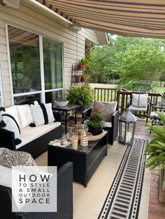 an outdoor patio with black wicker furniture and white cushions on the front porch area