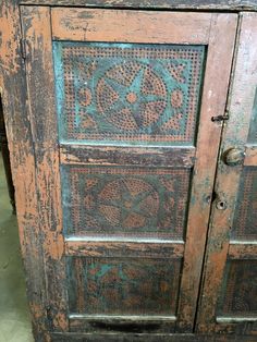 an old wooden cabinet with decorative designs painted on it