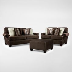 a living room set with brown furniture and pillows on top of it's back