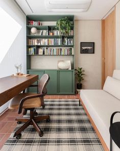 a room with a couch, desk and bookshelf