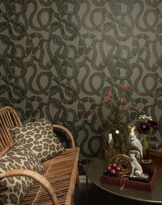 two wicker chairs sitting next to each other near a table with flowers on it