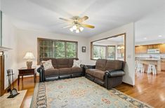 a living room with two couches and a rug in front of the fireplace area