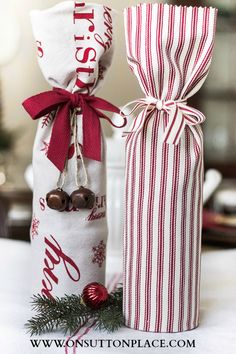 two wrapped wine bottles sitting on top of a table