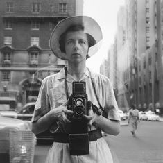 a woman with a camera standing in the street