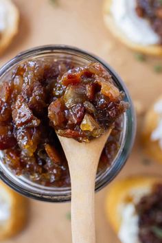 a spoon full of jam sitting on top of crackers