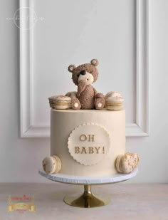 a baby shower cake with a teddy bear on top