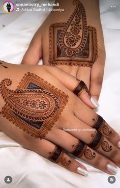 two hands with henna tattoos on them