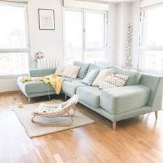 a living room filled with lots of furniture next to two windows and a rug on the floor