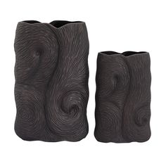 two black vases sitting next to each other on a white surface with wavy designs