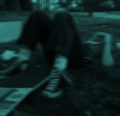 a blurry photo of someone's feet on a skateboard in the grass