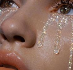 a close up of a woman's face with glitter on her eyes and nose