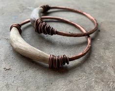 two bracelets with wooden beads on top of concrete floored area next to each other