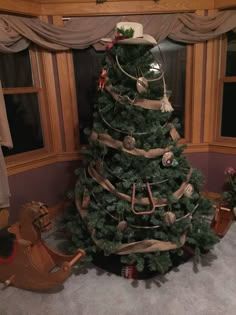 a christmas tree decorated with ribbons and ornaments