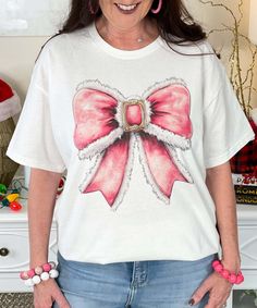 The Pink Santa Bow Graphic Shirt features a whimsical pink Santa bow design, perfect for adding a fun and festive touch to your Christmas wardrobe. Available in sizes YXS to 5XL, and offered in short sleeve, long sleeve, and sweatshirt styles, this shirt is a playful and stylish option for celebrating the holiday season with a unique, girly twist! Christmas Wardrobe, Bow Graphic, Pink Santa, Bow Design, Graphic Shirt, Graphic Shirts, The Pink, Sweatshirt Fashion, The Holiday