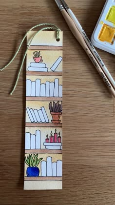 a bookmark with books on it next to paintbrushes