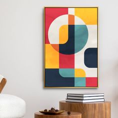 an abstract painting hangs on the wall above a white chair and side table with books