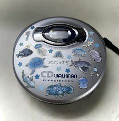 a round metal container with various stickers on it's lid sitting on a table