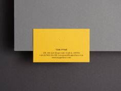 a yellow business card sitting on top of a gray surface