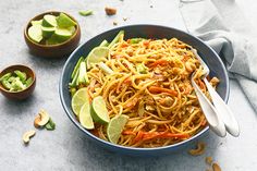 a bowl filled with noodles and vegetables on top of a table