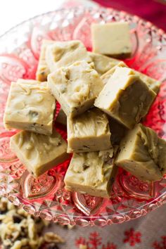 pieces of fudge fudge on a red glass platter with nuts around it