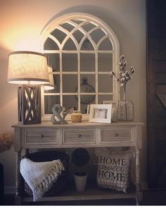 a white table topped with a mirror next to a lamp