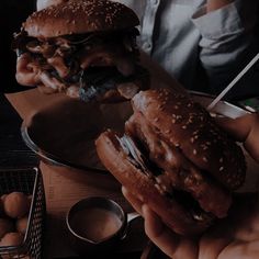 two hamburgers are being held in their hands