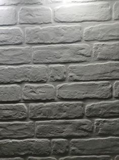 a brick wall is shown in black and white with light coming from the top right corner