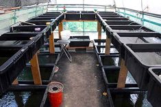 the inside of a boat filled with lots of black plastic containers and water buckets