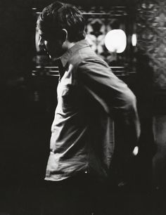 black and white photograph of a man talking on a cell phone in a dark room