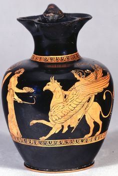 a black vase with gold painted designs on it's sides and an animal in the middle