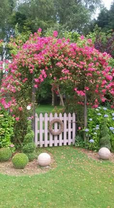 a white picket fence surrounded by pink flowers