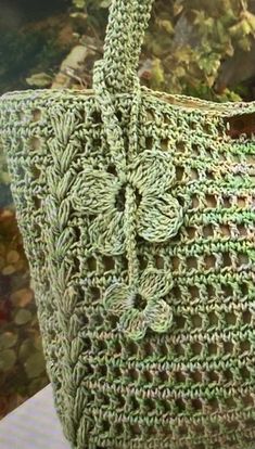 a green crocheted bag sitting on top of a table