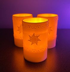 three lit candles sitting next to each other on a table