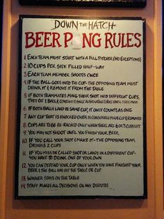 a sign that is on the wall in front of a table with drinks and other items