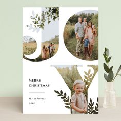 a christmas card with an image of two people and the number 50 on it, surrounded by greenery