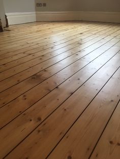 an empty room with hard wood floors and white walls